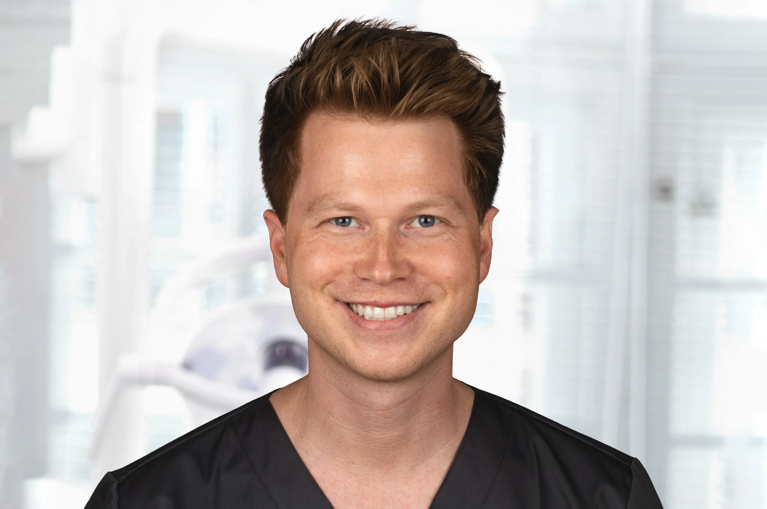 Porträt von Dr. Marius Müller mit Brille und dunkler Praxiskleidung, lächelt freundlich in die Kamera – Mitarbeiter der Praxis Dr. Bayer & Kollegen.