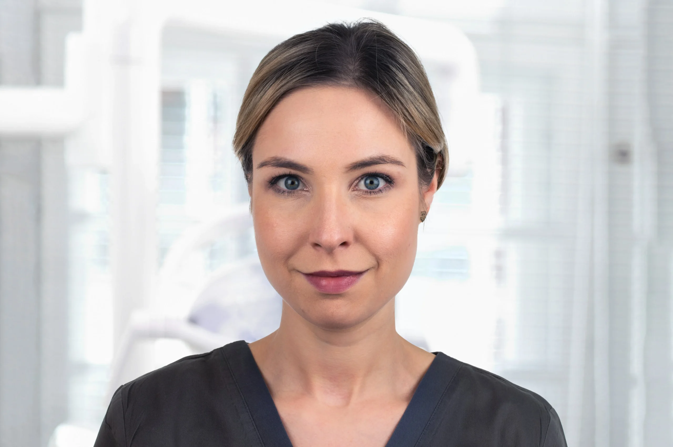 Porträt von Dr. Luise Krüger mit dunklblauem Kasack und ruhigem Blick – Zahnärztin bei Dr. Bayer & Kollegen in Landsberg, spezialisiert auf Ästhetisch-Rekonstruktive Zahnheilkunde.