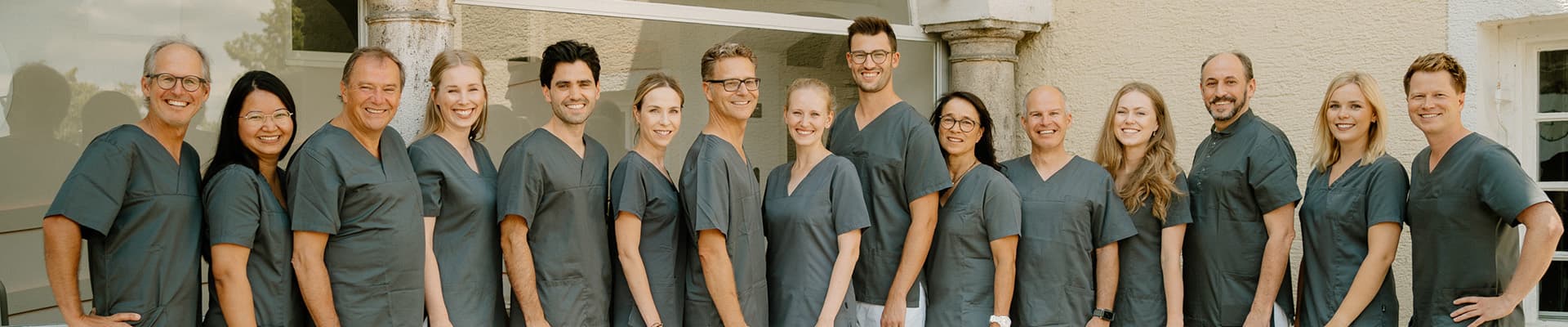 Das Team der Zahnarztpraxis Implantate Landsberg steht gemeinsam vor der Praxis – kompetente Zahnärzte, Zahnärztinnen und Fachkräfte im Gruppenfoto.